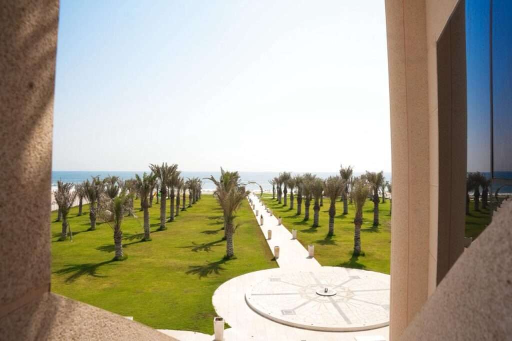 إطلالة من الشاليه على الحديقة الخضراء والنخيل والبحر – View from the chalet over the green lawn, palms and the sea