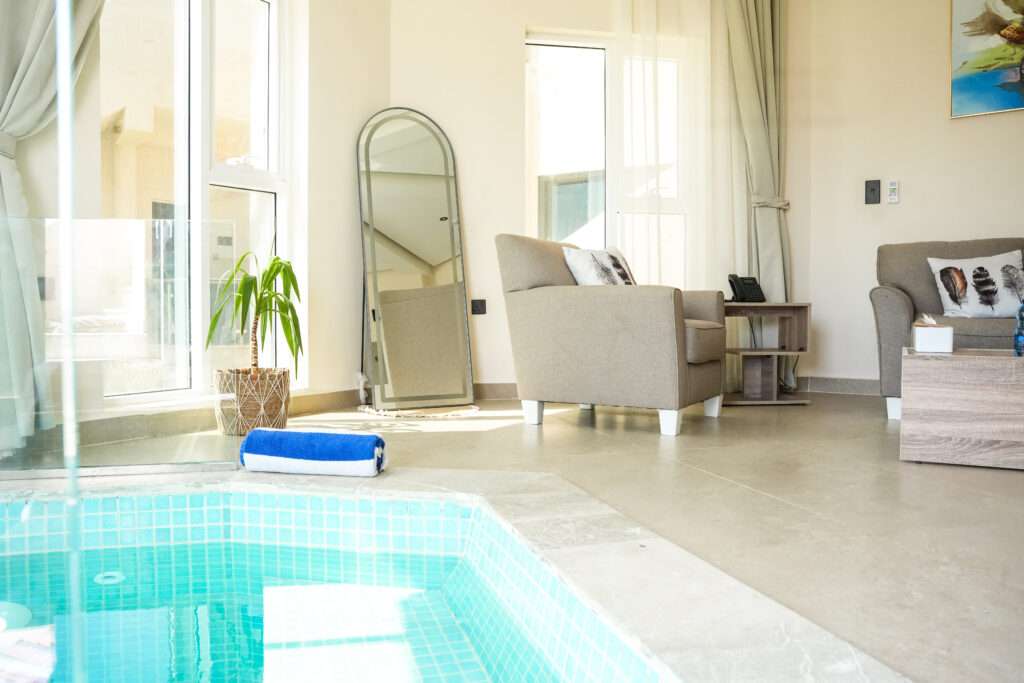 صالة الشاليه مع مسبح داخلي خاص وأريكة – Chalet living room with private indoor pool and sofa