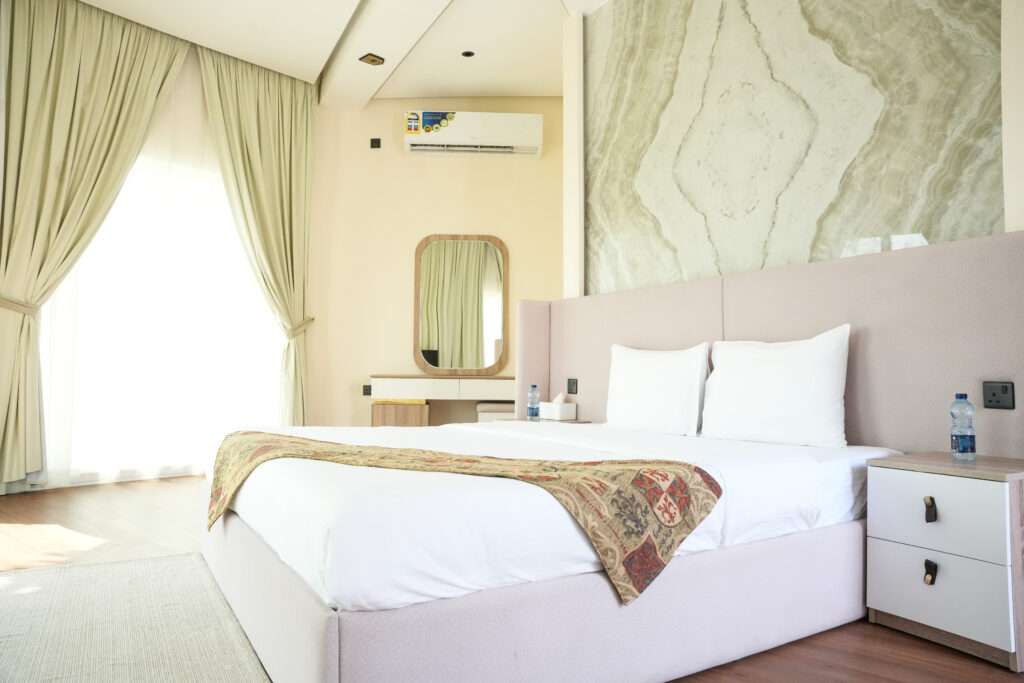 غرفة نوم بسرير مزدوج وجدار رخامي – Bedroom with double bed and marble feature wall